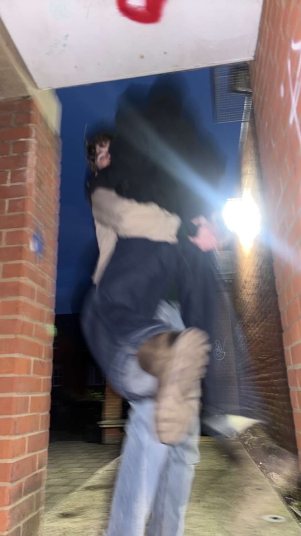 A blurred night-time candid photograph with brick walls and bright light